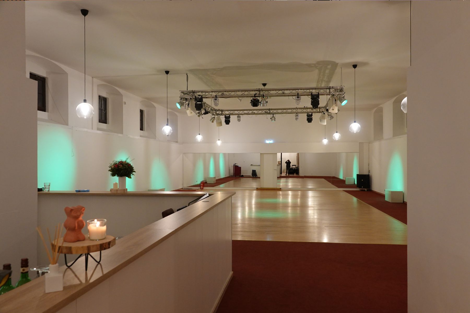 Großer, flexibler Veranstaltungsbereich im Marstall Gotha mit hochwertigem Parkettboden und elegantem rotem Teppich, der eine stilvolle Atmosphäre schafft. Der Raum ist vielseitig nutzbar für verschiedene Events und bietet Komfort und Exklusivität für bis zu 180 Gäste.