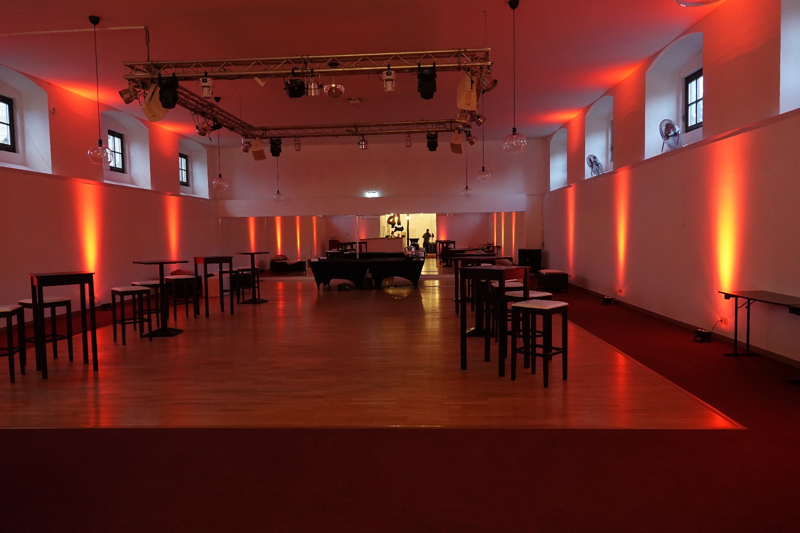 Moderner Bereich im Marstall Gotha mit Stehtischen und stimmungsvoller Ambientebeleuchtung, ideal zum Netzwerken und Austausch. Der Networkingplace﻿ bietet eine entspannte Atmosphäre für berufliche Kontakte und informelle Gespräche.